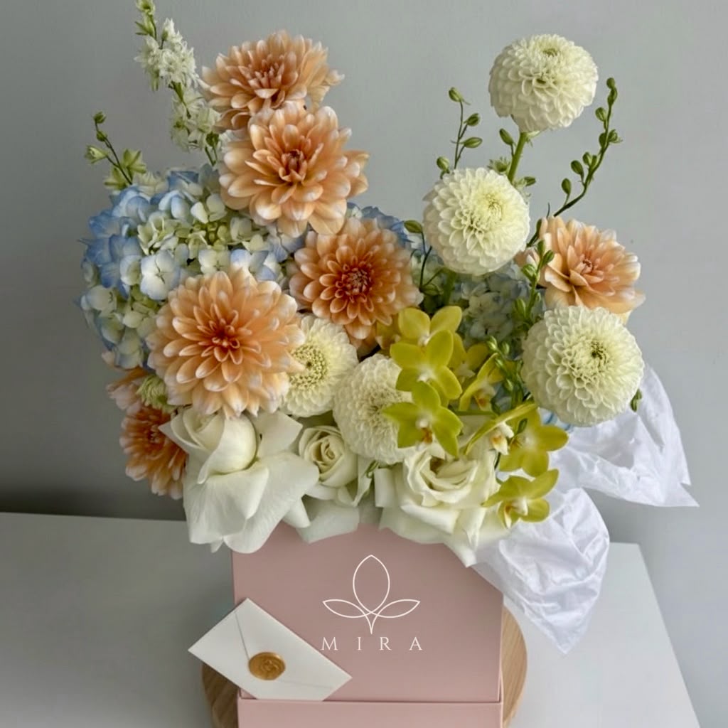Pastel Bloom Suite - Peach dahlias, white roses, blue hydrangeas, and green orchids in MIRA pink gift box